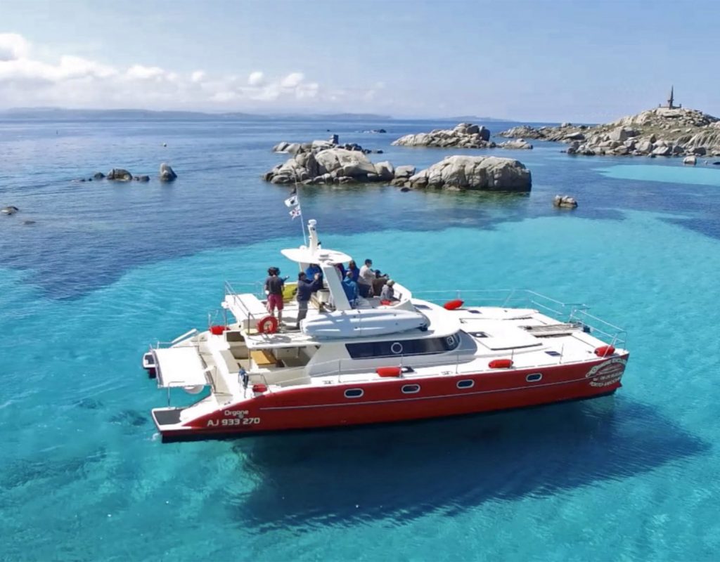 Bateau sur de l'eau cristalline navigant à l'archipel des îles Lavezzi